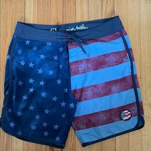 Travis Mathew Blue and Red Board Shorts with Vintage Flag Design